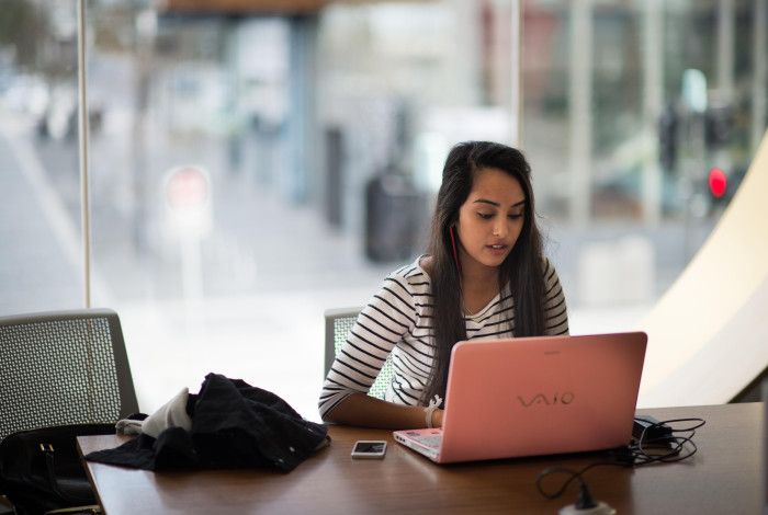 Image: a person using the library to access online resources on a laptop