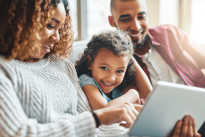 Man and a woman looking at a laptop with a child