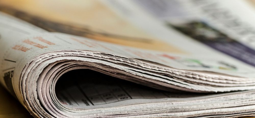 Newspaper folded on a table.