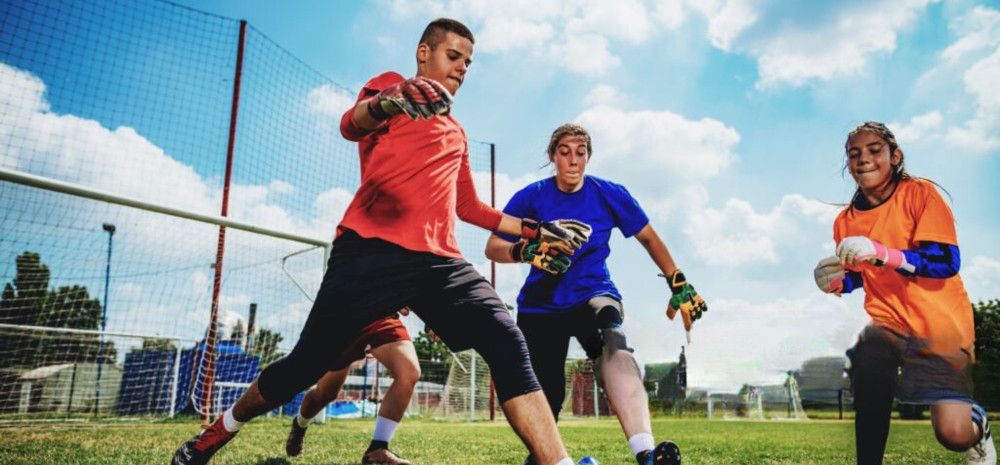 Young people playing soccer on a field.
