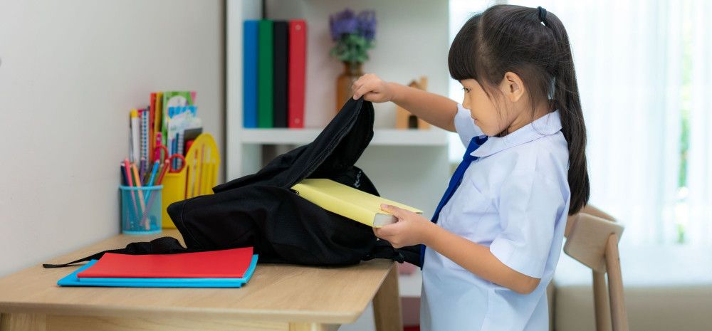 A girl packing her books for school