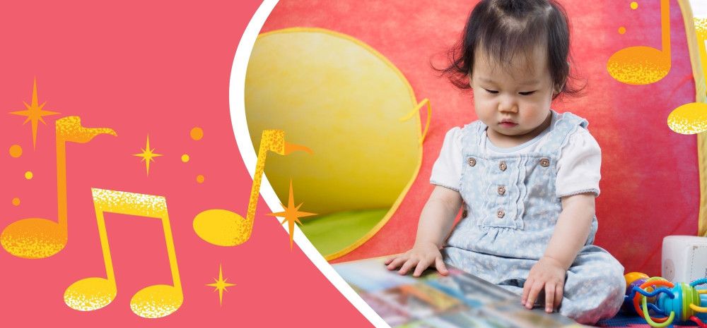 Seated toddler looking at a picture book.