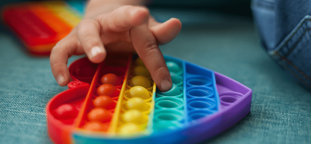 Heart shaped rainbow coloured sensory toy.