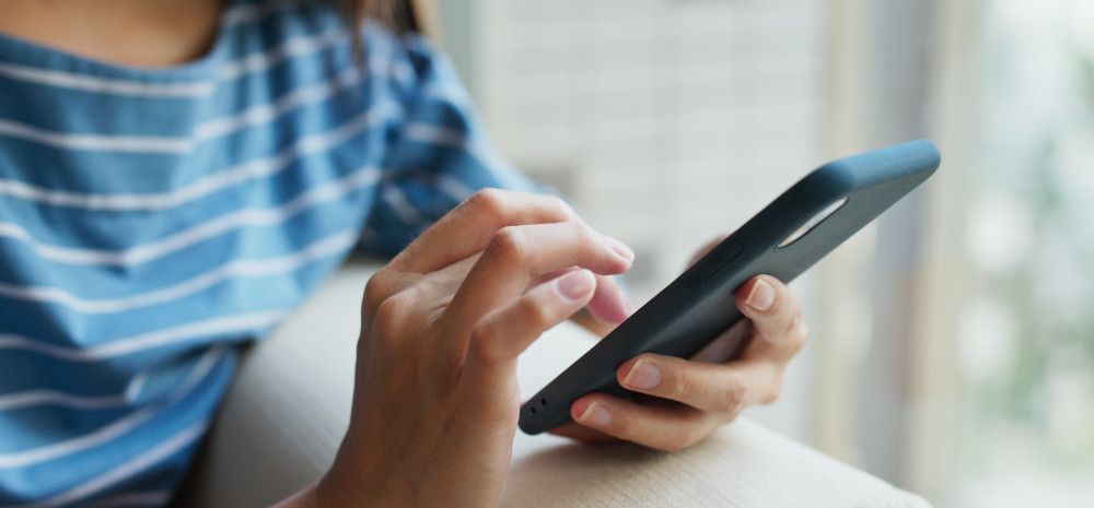 Closeup of a person's hands using a mobile phone.