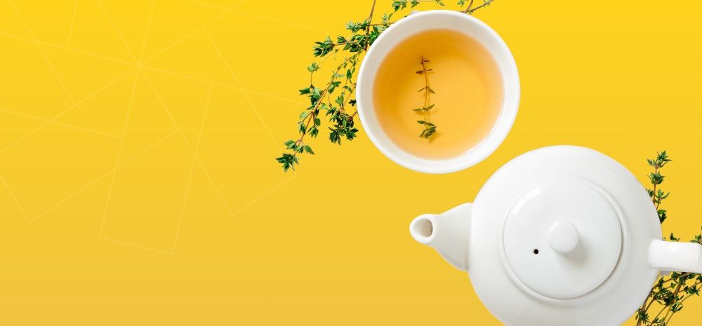 Teapot, herbs and tea in a cup.