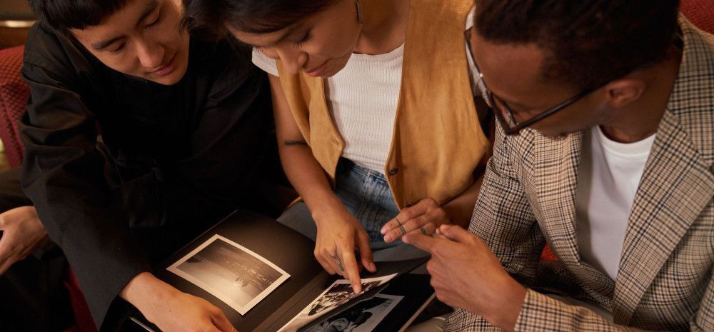 Group of people leafing through a photo album.