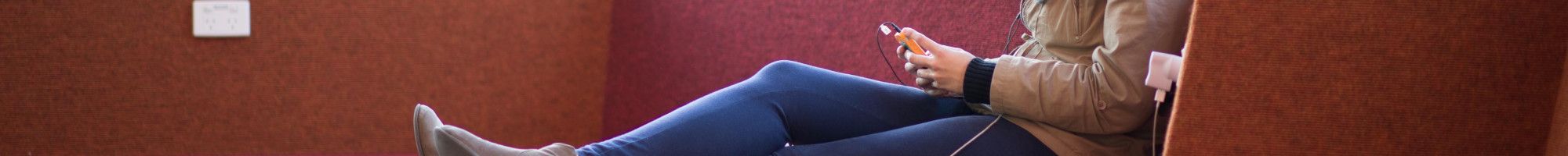 A person reading an eBook on a mobile device in the library