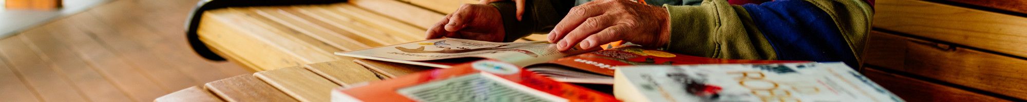 Image: Man reading a book to his grandchild at the library