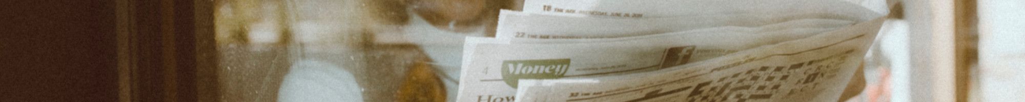 A person reading The Age newspaper