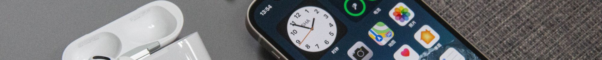 Image: A phone, earpods and laptop computer on a fabric surface.