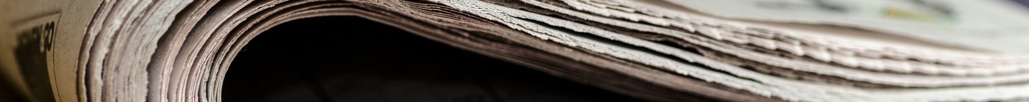 Newspaper folded on a table.