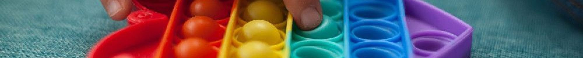 Heart shaped rainbow coloured sensory toy.