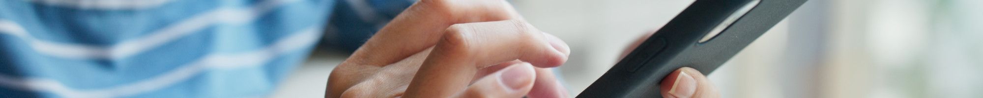Closeup of a person's hands using a mobile phone.