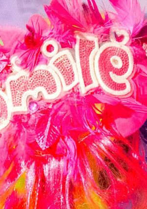 Brightly coloured feathers and the word 'smile' appears.