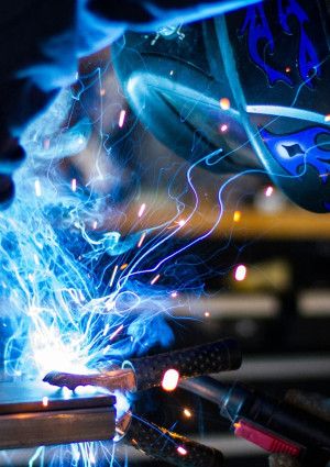 Figure in protecting clothing welding or electroplating.