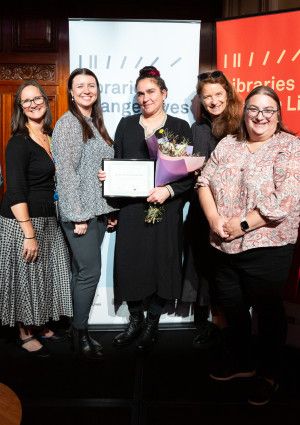 A number of people gathered on a stage receiving an award.