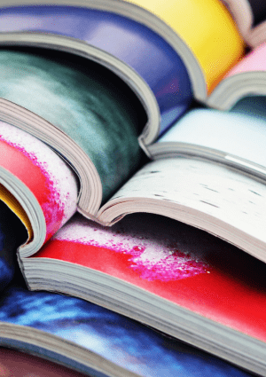 A number of open magazines stacked up on top of each other.