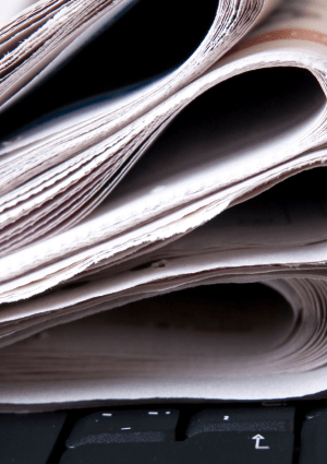 Folded newspapers on a laptop keyboard.