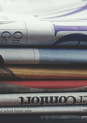 Newspapers folded and stacked on top of each other.