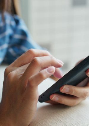 Closeup of a person's hands using a mobile phone.